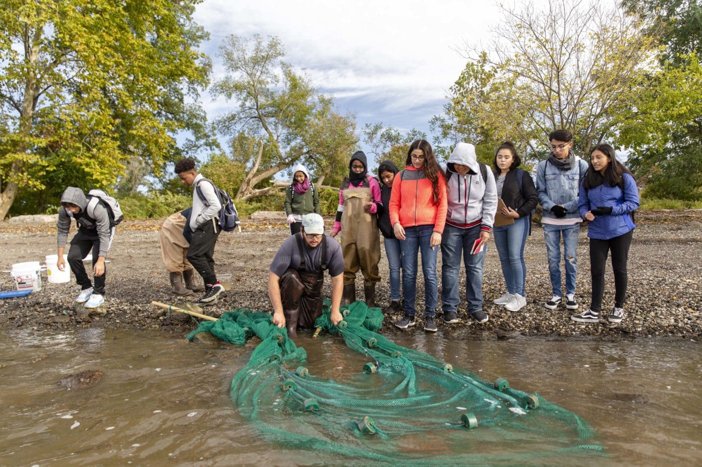 Teens seining for river creatures.