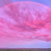 The full arc of a monochromatic, pink rainbow over the Hudson Valley.